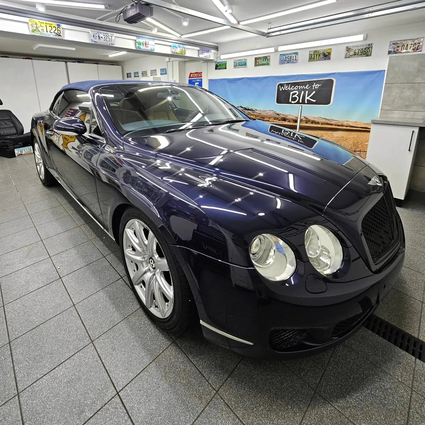 Granatowy Bentley Continental GT ustawiony bokiem w studiu