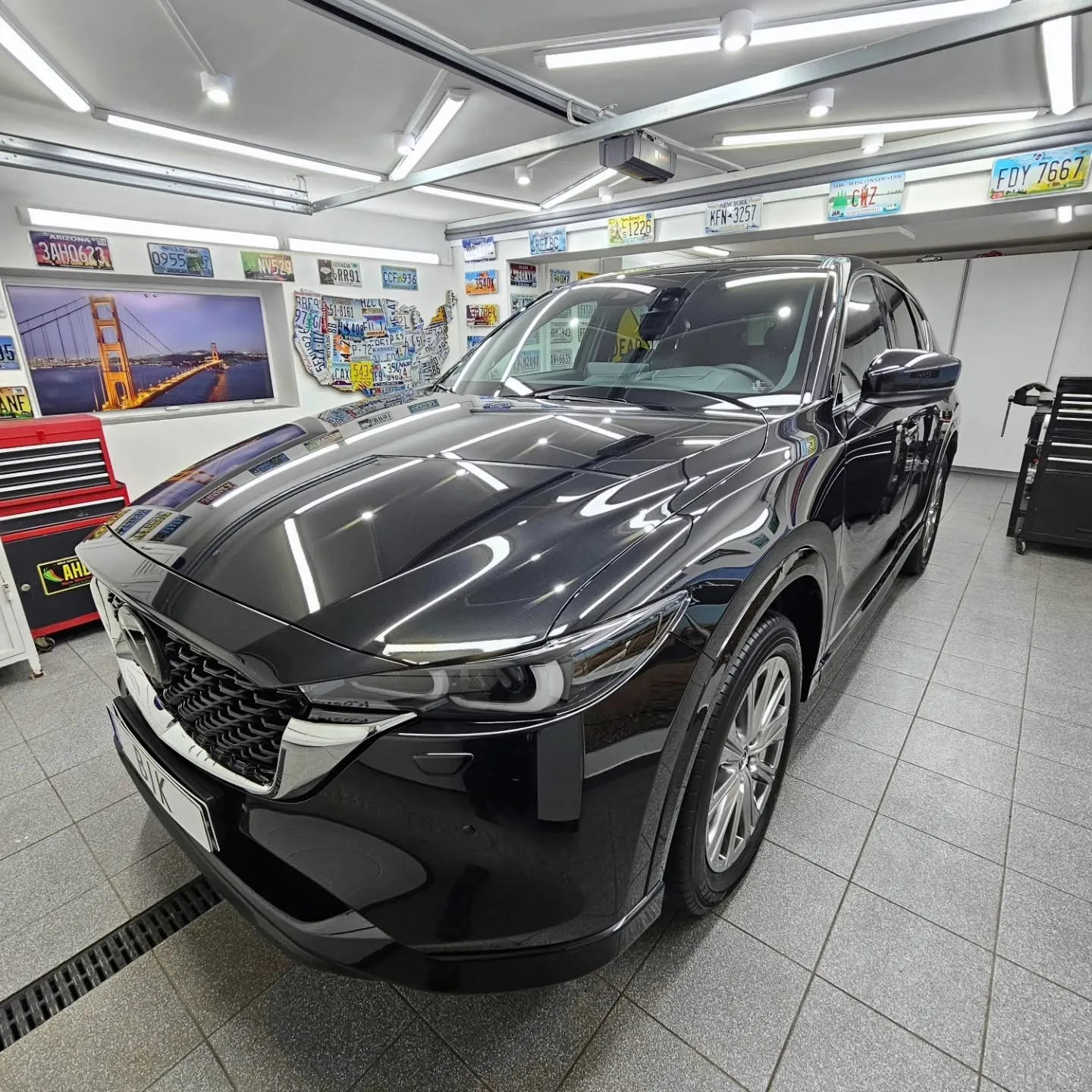 Czarna Mazda CX-5 w studiu BIK na tle ściany z amerykańskimi tablicami