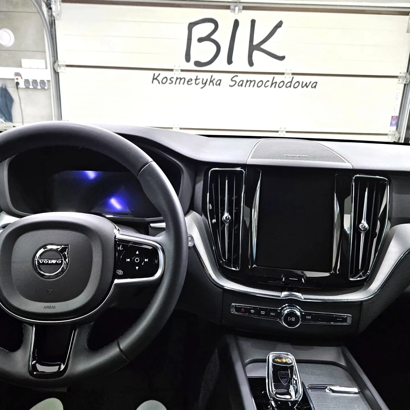 Kokpit Volvo XC60 po czyszczeniu wnętrza, w tle logo BIK na bramie